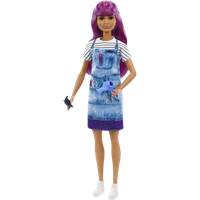 Barbie Career Hairdresser Doll with purple hair, striped shirt, denim apron, holding scissors and hairdryer.