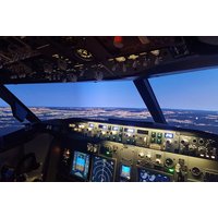 Flight simulator cockpit with illuminated control panels and scenic landscape view through windows.