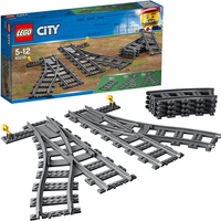 Lego City 60238 set with gray train switch tracks, including curved and straight pieces, in front of a colorful box.