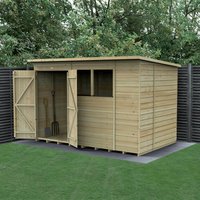 Wooden shiplap shed with double doors, two windows, and a flat roof, set on a grassy area with trees in the background.