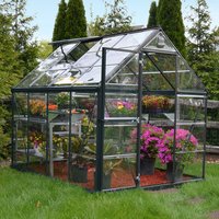 Grey polycarbonate greenhouse with clear panels, pitched roof, and walk-in door, filled with potted plants.