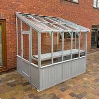 Green-painted wooden lean-to greenhouse with clear glass panels and sloped roof, measuring 8'1 x 6'4.