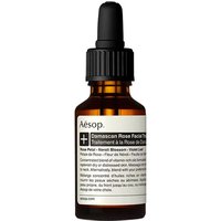 Amber glass bottle with black dropper cap, labeled "Aesop Damascan Rose Facial Treatment" for dry skin.