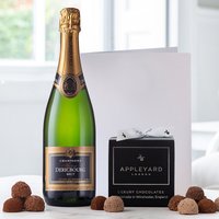 Champagne Dericbourg bottle, black box of 12 handmade chocolate truffles, and a white occasion card.