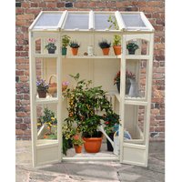 Victorian tall wall greenhouse with cream frame, clear panels, and shelves holding various potted plants.