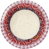 White Fragonard soap with floral embossing on a decorative red and purple patterned soap dish.