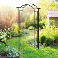 Black metal garden arch with wave top design, standing 7'4" tall, set in a lush garden setting.