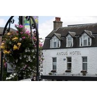 White Angus Hotel building with slate roof, flower baskets, and "Angus Hotel" sign on facade.