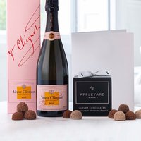 Veuve Clicquot Rosé Champagne bottle with pink box, black box of 12 truffles, and white occasion card.