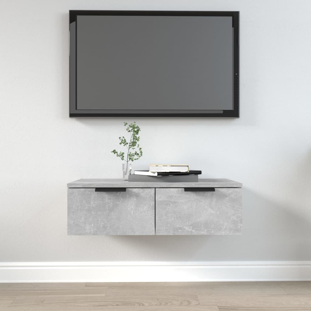 Concrete grey wall cabinet made of engineered wood, featuring two drawers with sleek handles, positioned beneath a flat-screen TV, complemented by decorative items on top.