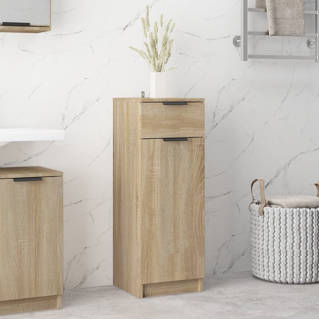 Sonoma oak bathroom cabinet in engineered wood, featuring a sleek design with a top drawer and bottom cabinet, complemented by a decorative vase and textured basket nearby.