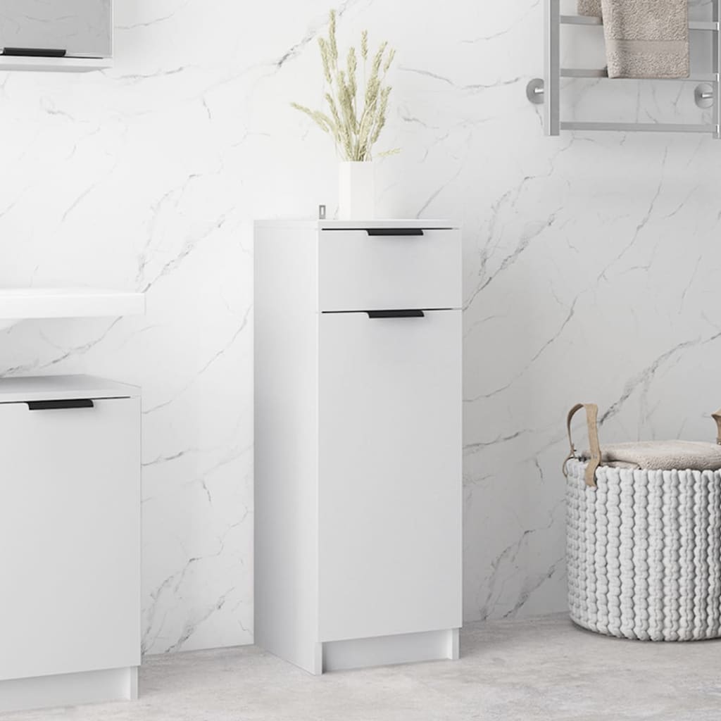 White bathroom cabinet made of engineered wood, featuring two drawers with black handles, set against a marble wall, with a decorative plant on top.