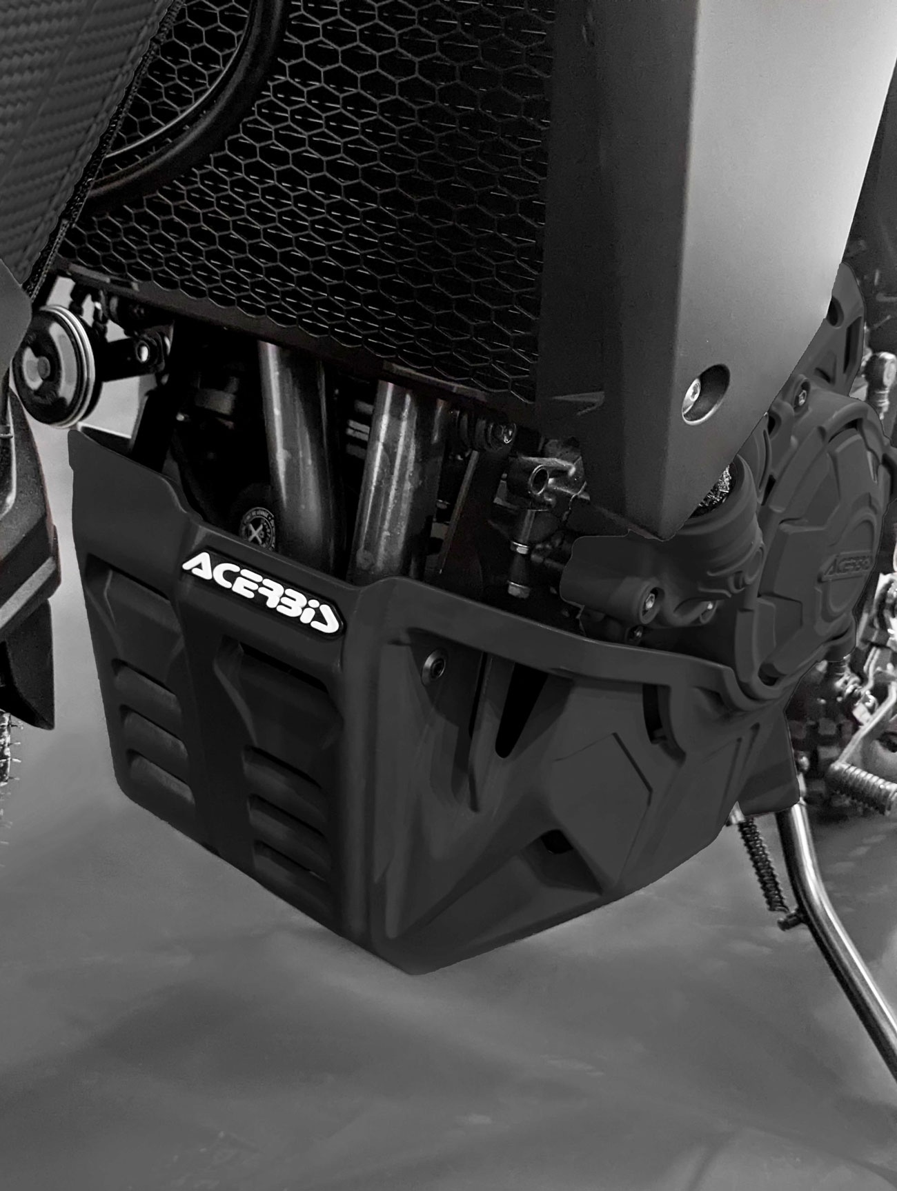 Black Acerbis skid plate for Honda Transalp XL750, featuring a rugged design with ventilation slots and a prominent logo, designed for enhanced protection and durability.