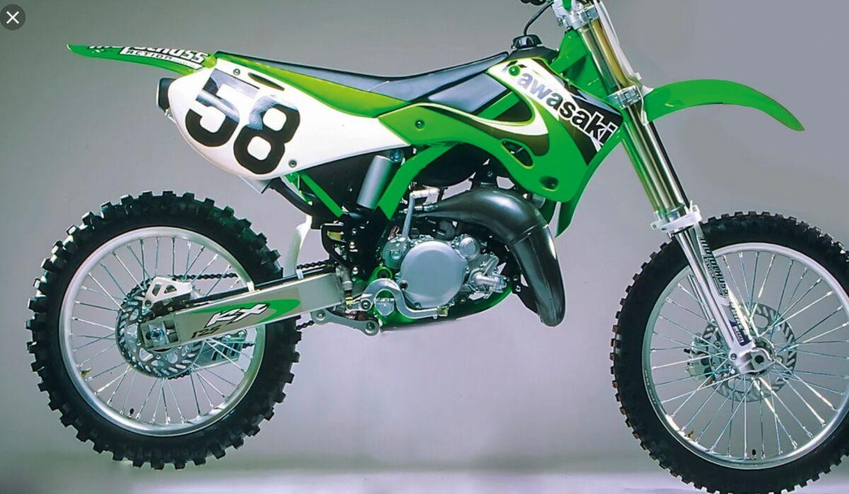 Black and green Tecnosel seat cover designed for Kawasaki KX125 (1999-2002), featuring a sleek design and durable material, enhancing the bike's sporty appearance.