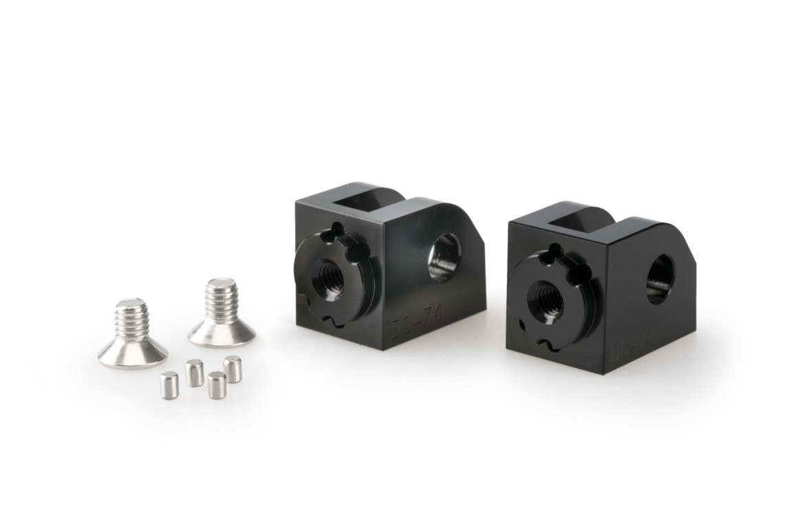 Black aluminum adjustable footpeg adaptors for Yamaha MT-07, featuring a square design with mounting holes, accompanied by silver screws and spacers.