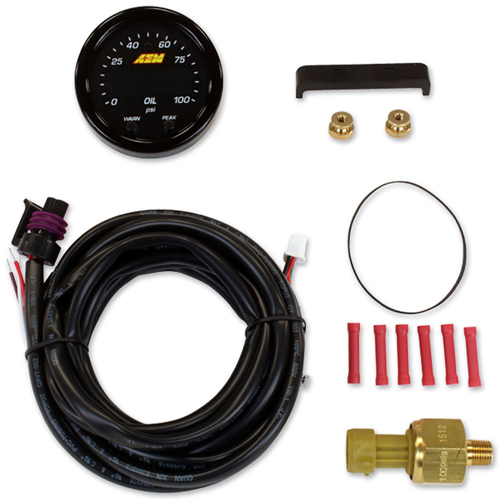 Black circular gauge with a white dial displaying oil pressure readings, accompanied by a wiring harness, brass fittings, and red connectors.