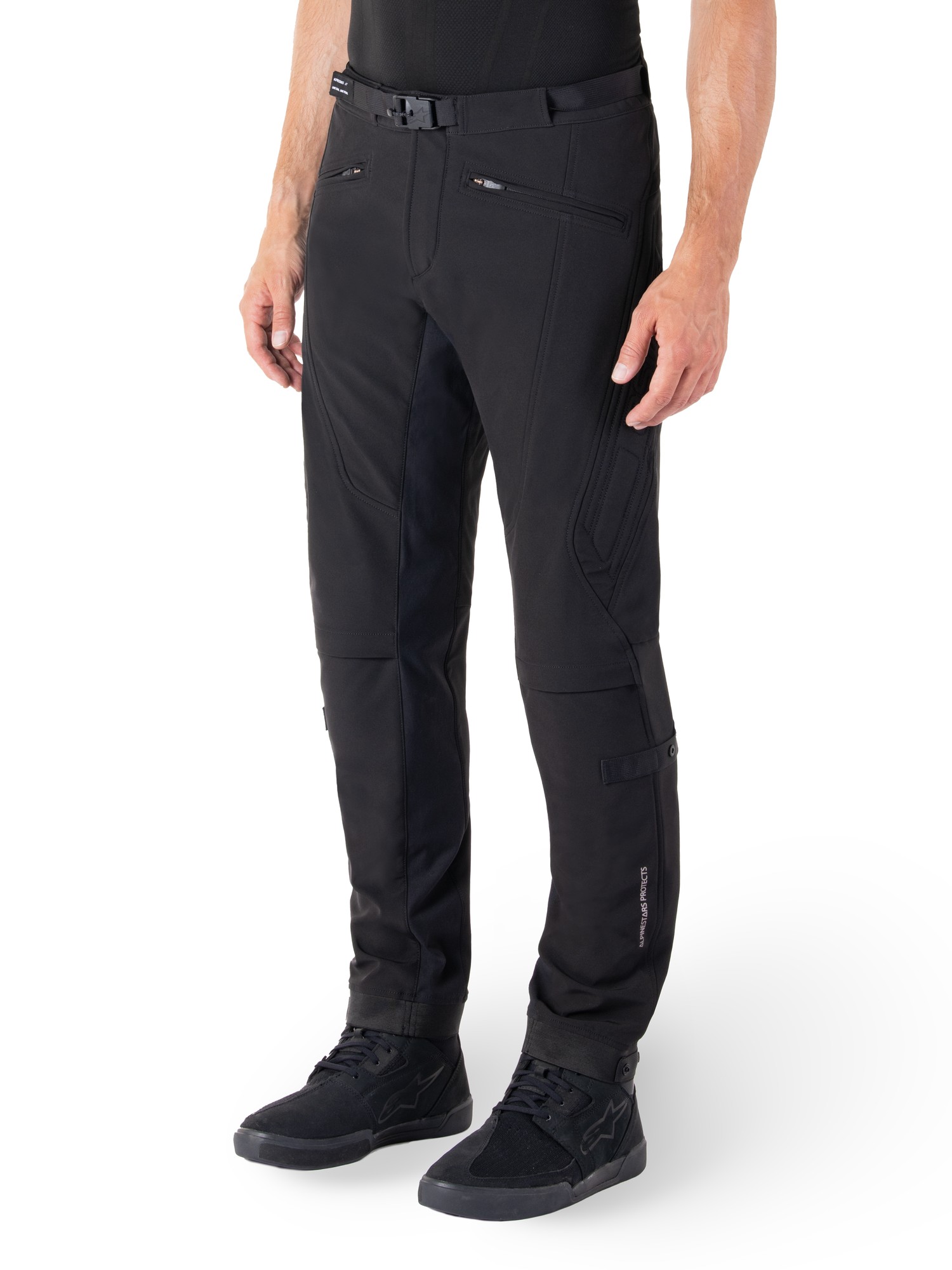 Black textile pants with a slim fit, featuring zippered pockets, reinforced knee areas, and adjustable waist, designed for comfort and durability in outdoor activities. Size 38.