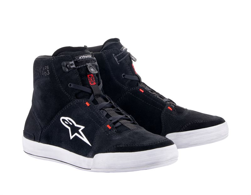 Black and gray suede riding shoes with red accents, featuring a high-top design, lace-up front, and prominent white Alpinestars logo on the side.