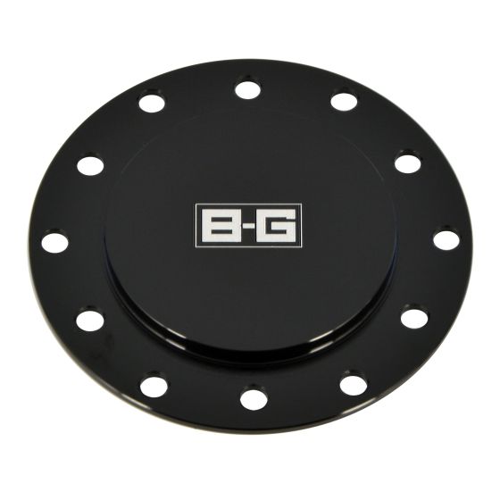 Black aluminum steering wheel horn button blanking plate featuring a smooth center and multiple mounting holes, with a prominent B-G Racing logo in the center.
