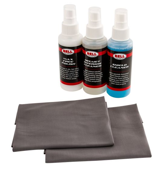 Three spray bottles labeled "Bell" in red and black, containing helmet cleaner, polish, and shield cleaner, accompanied by two gray microfiber cloths.