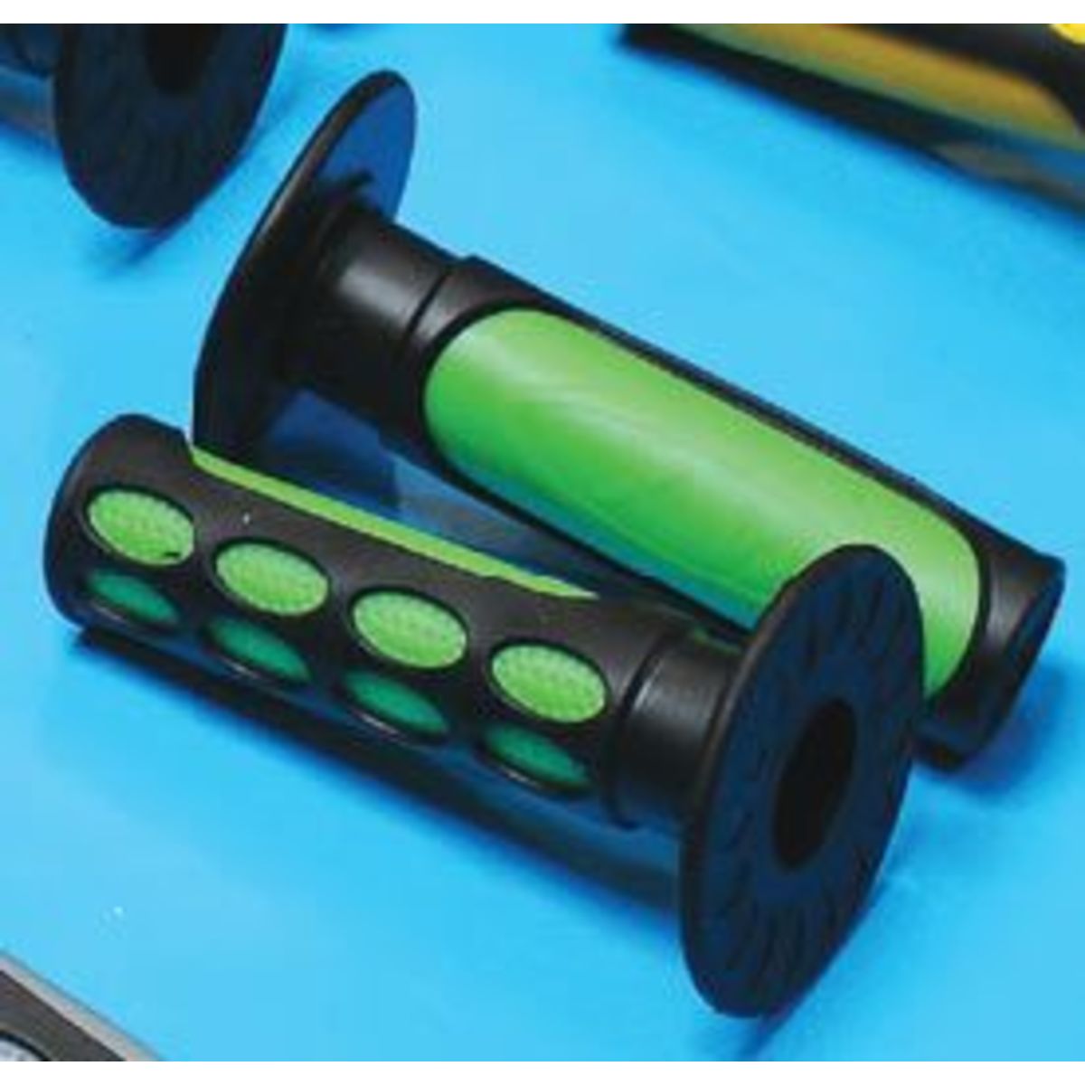 Two-tone MX grips featuring a green rubber center with textured black ends, measuring 20 mm x 25 mm, designed for enhanced grip and control on bikes.