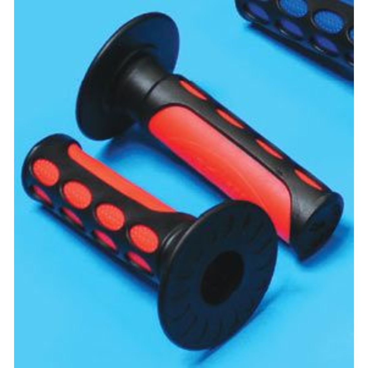 Two-tone MX grips in orange and black, featuring a textured surface with circular cutouts for improved grip, measuring 20 mm x 25 mm, designed for enhanced control on bikes.