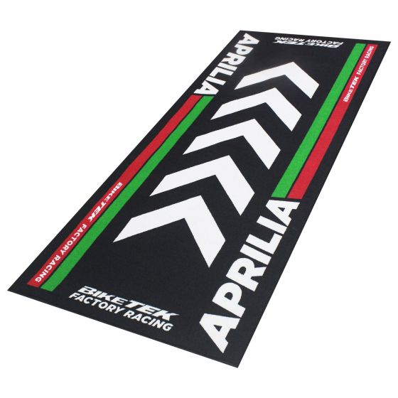 Black carpet with a textured surface featuring a prominent white chevron pattern, red and green accents, and "APRILIA" branding in bold letters, designed for motorcycle enthusiasts.