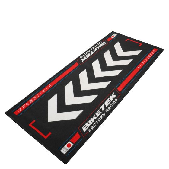 Black carpet featuring bold white chevrons and red accents, branded with "BikeTek" and "Factory Racing," designed for an environmentally friendly touch.