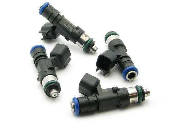 Four fuel injectors with black plastic bodies, silver metal tips, and blue and green O-rings, designed for DeatschWerks 650cc applications in A4/TT and Golf GTI 1.8L Turbo models.