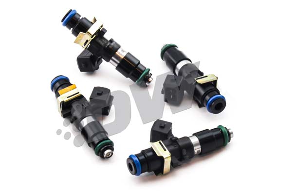 Four DeatschWerks fuel injectors, featuring black and metallic bodies, green and blue O-rings, and gold clips, designed for high-performance applications with a 1200cc capacity.
