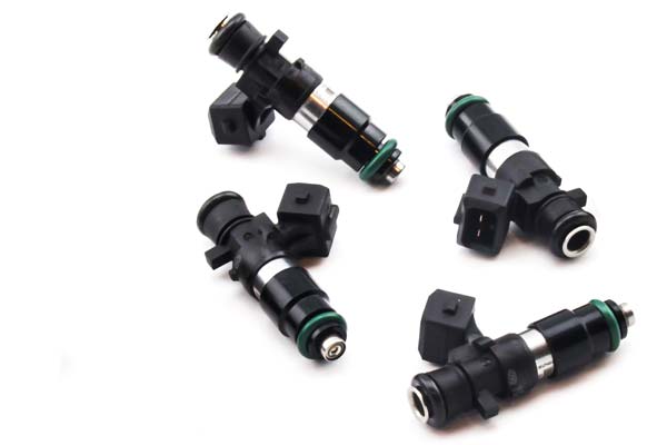 Four black fuel injectors with green O-rings and electrical connectors, designed for DeatschWerks 1200cc applications in A4/TT and Golf GTI 1.8L Turbo models.