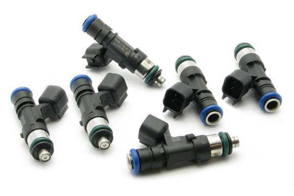 Set of six black fuel injectors with blue and green accents, featuring metal tips and electrical connectors, designed for 2005-2010 Ford Mustang by DeatschWerks.