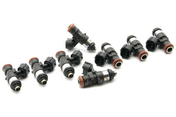 Black and silver fuel injectors with orange O-rings, featuring electrical connectors, arranged in two rows, designed for Cadillac, Chevrolet, and Pontiac vehicles.