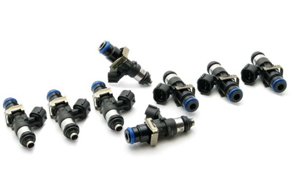 Eight black and silver fuel injectors with blue accents, featuring a cylindrical design and a connector at one end, arranged neatly on a white background.