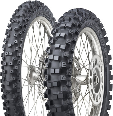 Black Geomax MX 53 F tires by Dunlop, featuring a rugged tread pattern for off-road performance, mounted on silver metal rims with visible spokes.