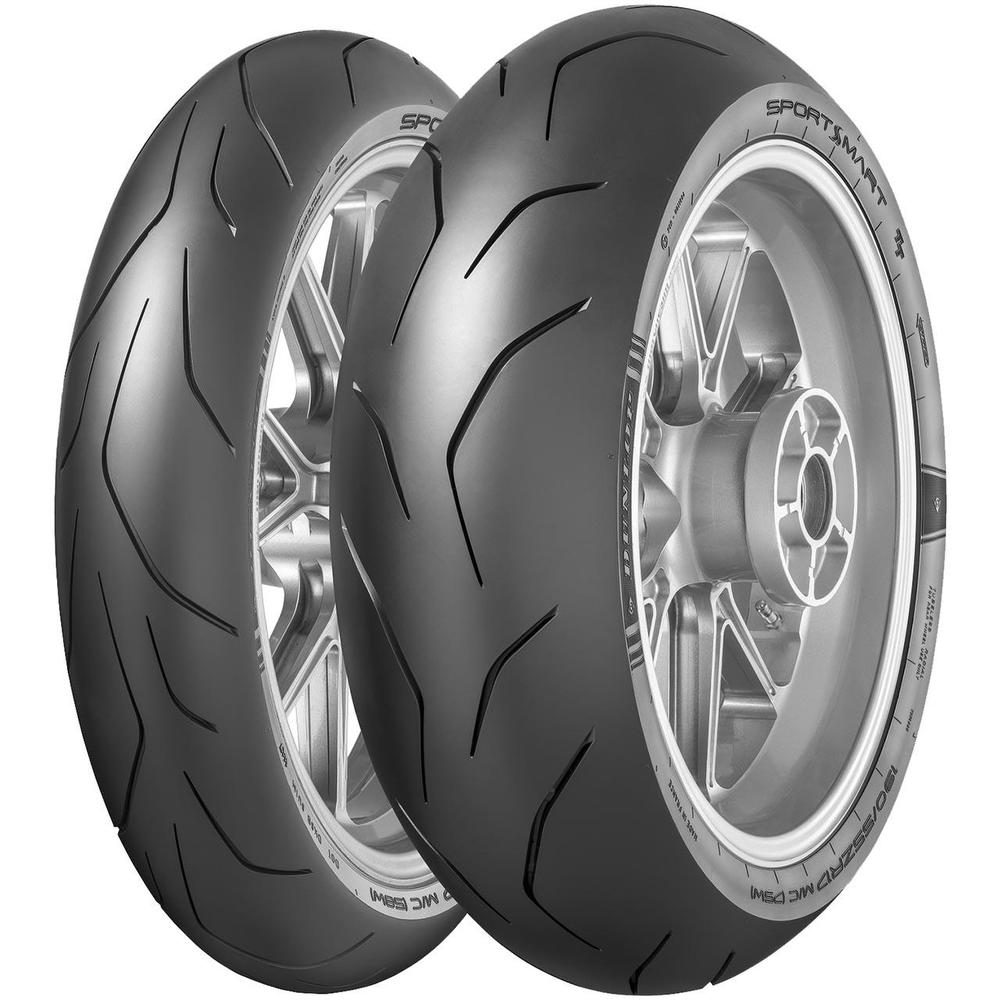 Dunlop Sportsmart TT motorcycle tires feature a sleek, black rubber surface with a distinctive tread pattern and a white sidewall stripe, designed for high-performance grip.