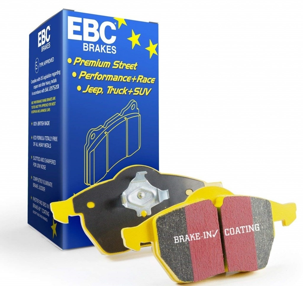 EBC Brakes Yellowstuff performance brake pads in yellow and red, featuring a unique coating, displayed alongside a blue box with branding and product details.