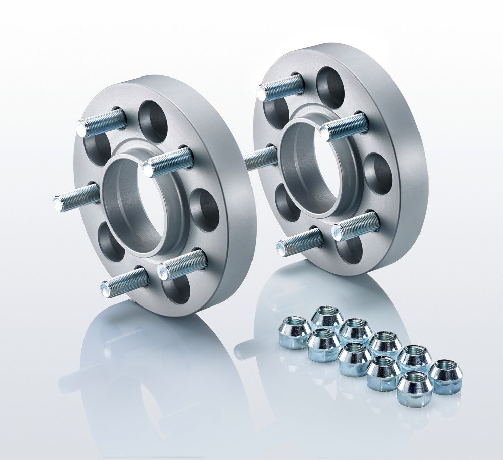 Silver aluminum track widening spacers with four holes each, designed for a 25mm widening per side, accompanied by chrome wheel nuts.