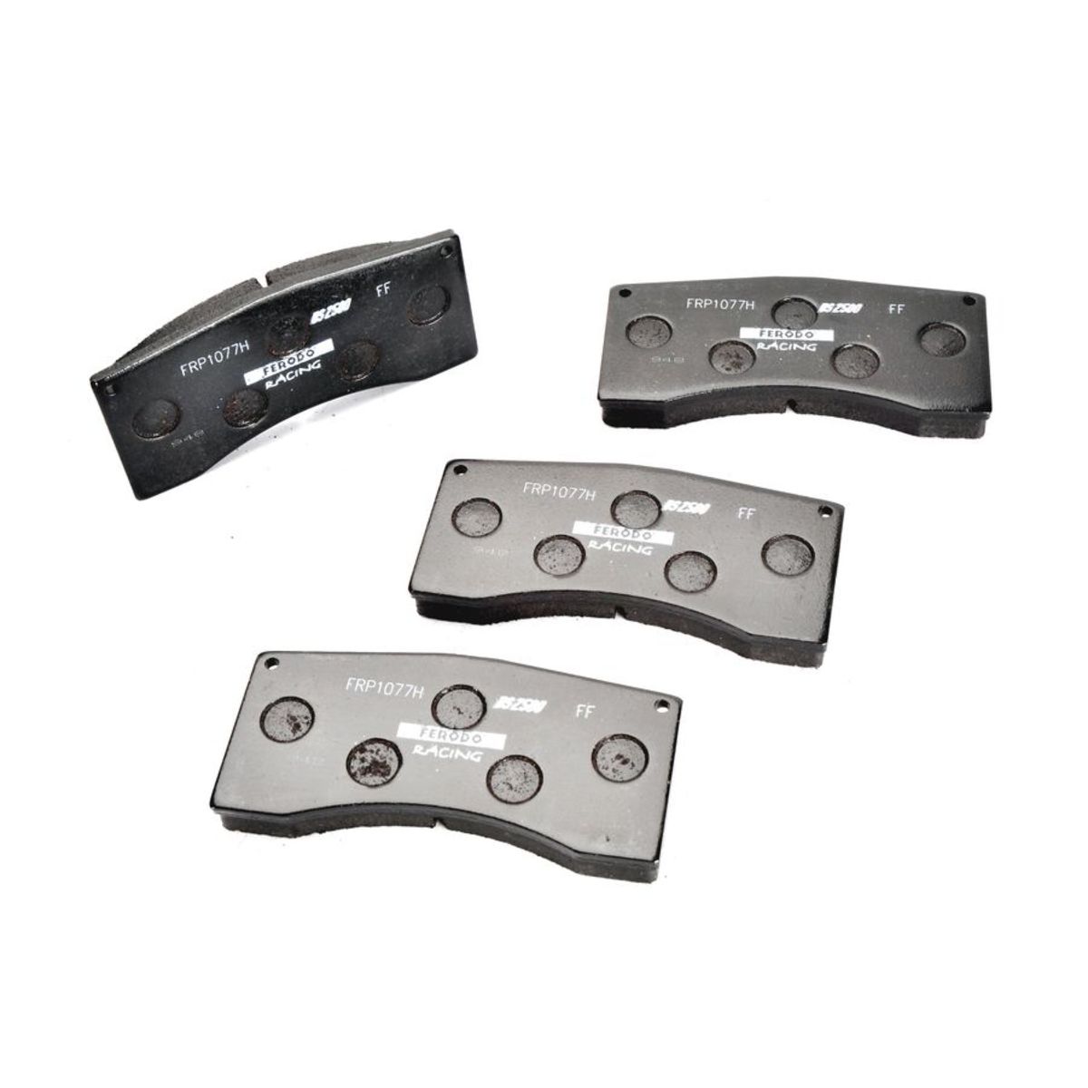 Black brake pad set featuring four pads with a textured surface, labeled "FRP1077H" and "DS2500," designed for high-performance racing applications.