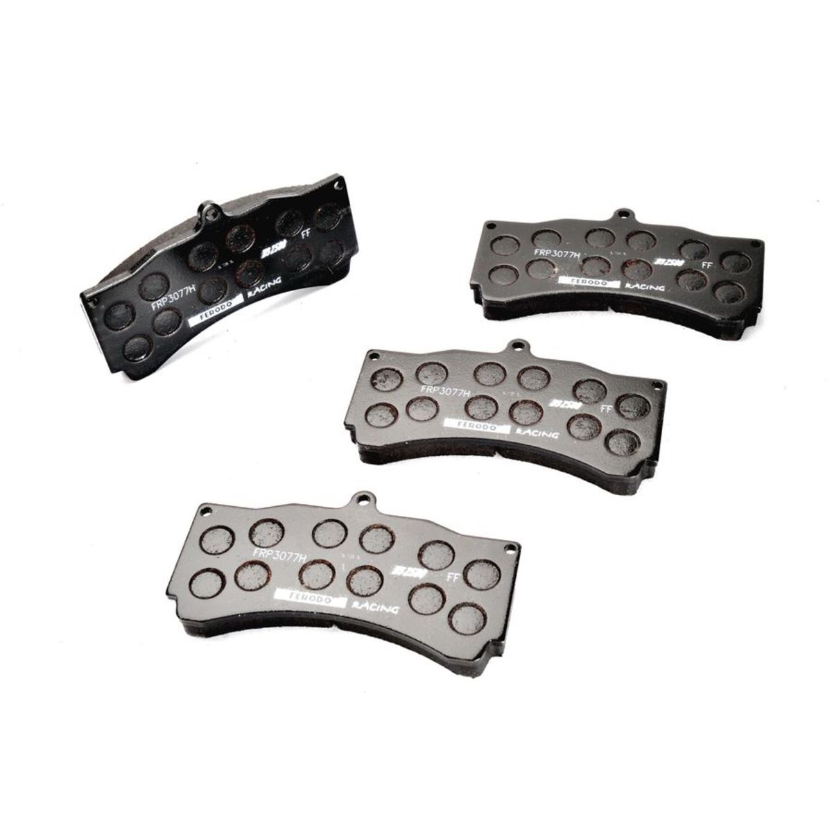 Black brake pad set featuring four pieces with a textured surface and multiple drilled holes for improved performance, labeled "FRP3077H" and "DS2500" by Ferodo Racing.