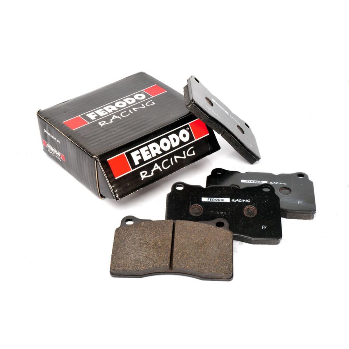 Black Ferodo DS2500 brake pads with a textured surface, featuring a distinctive shape, accompanied by a black and red branded box labeled "Ferodo Racing."