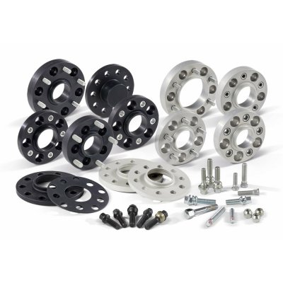 Track widening adapters in black and silver, featuring 5-hole designs, with accompanying bolts and washers for Audi, Seat, Skoda, and VW, providing 40mm track widening per axle.