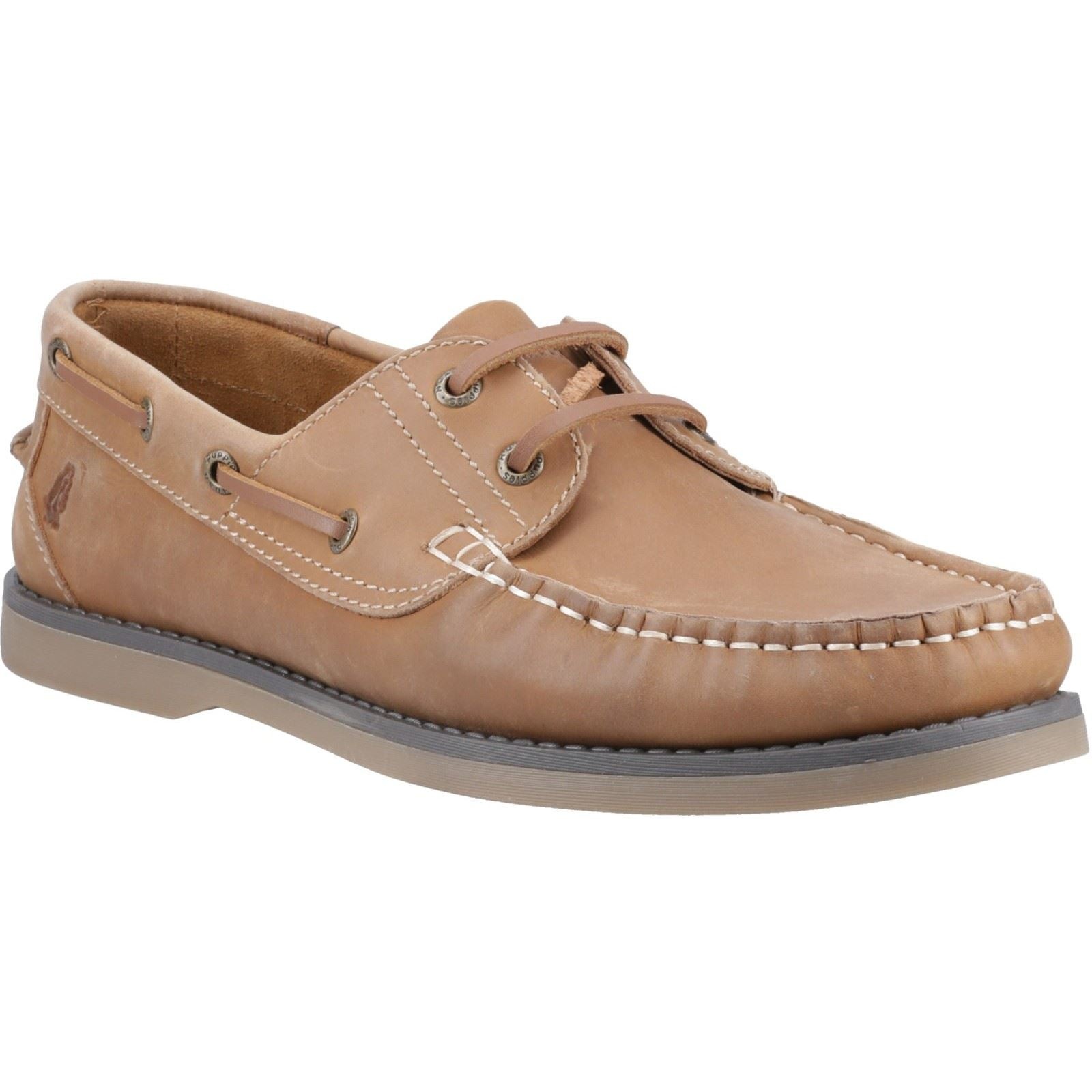 Tan leather boat shoe with white stitching, lace-up design, and a rubber sole, featuring a classic moccasin style and Hush Puppies logo on the side, size 6.
