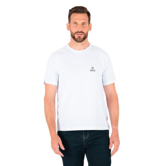 White short-sleeve t-shirt featuring a small Knox woven patch on the chest, made of soft material, paired with dark jeans for a casual look.