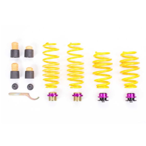 Yellow coil springs with purple top hats, black rubber bump stops, and metal adjustment tools, designed for height adjustment of 0-20mm, arranged neatly on a white background.