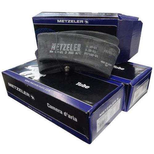Black rubber Metzeler off-road inner tube displayed on top of blue and white branded boxes, featuring size markings and a valve stem for inflation.