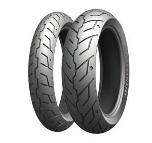 Two MICHELIN "Scorcher 21" motorcycle tires with a sleek, gray rubber surface, featuring a distinctive tread pattern for enhanced grip and performance.