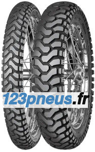Black rubber motorcycle tires with a rugged tread pattern, featuring a mix of deep grooves and raised sections, designed for off-road and trail riding, mounted on metal spokes.