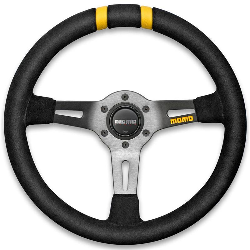Black suede steering wheel with a three-spoke design, featuring a silver center hub, Momo branding, and yellow accents on the grips.
