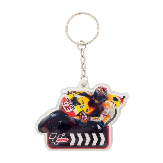 A colorful PVC keyfob featuring a racer in a yellow and red suit, leaning on a motorcycle, with a black and white chevron design at the base.